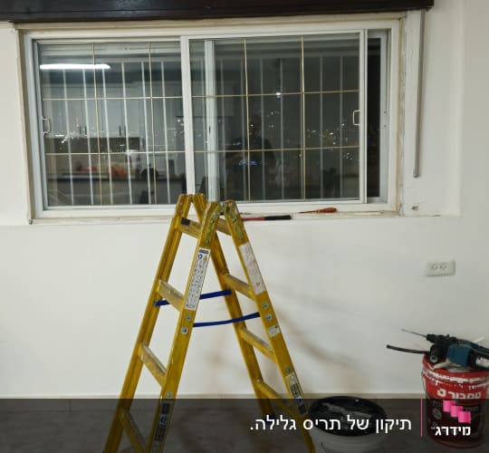 סולם וחלון עם תריסים, דלי צבע וכלי עבודה